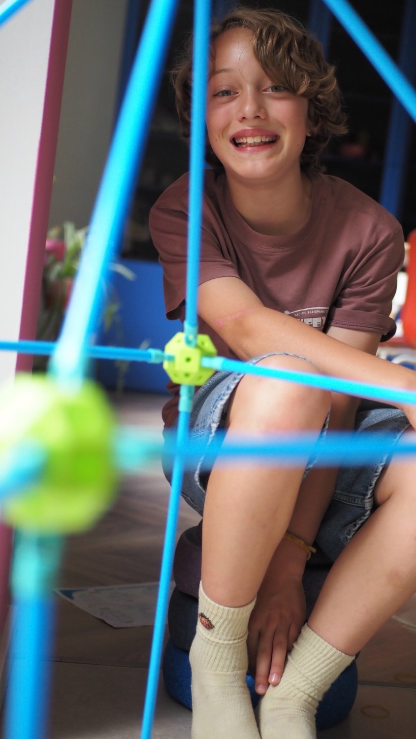 Jongen van vier lacht in zijn zelfgebouwde fort van het TinyPlay fort bouwpakket XXL