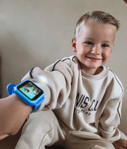 Jongen laat zijn blauwe TinyPlay smartwatch om zijn pols zien